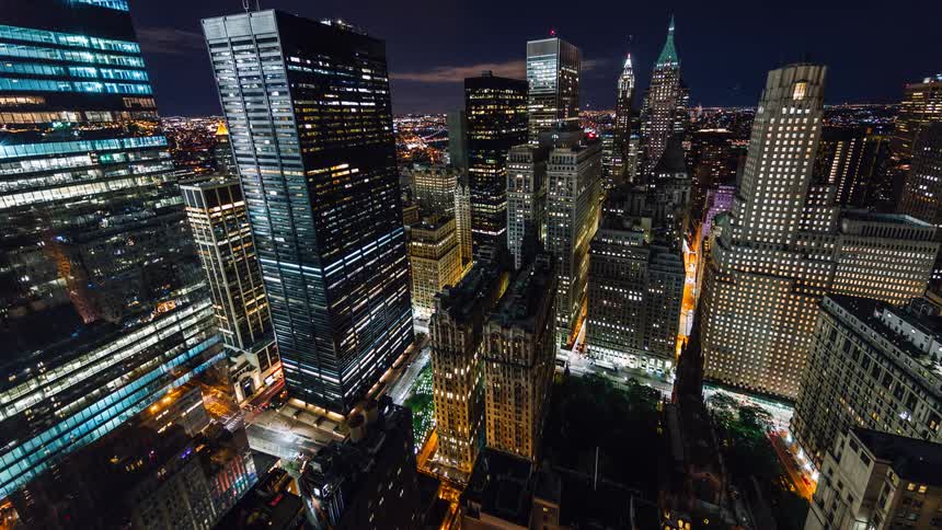 Cars drive fast down the city streets below