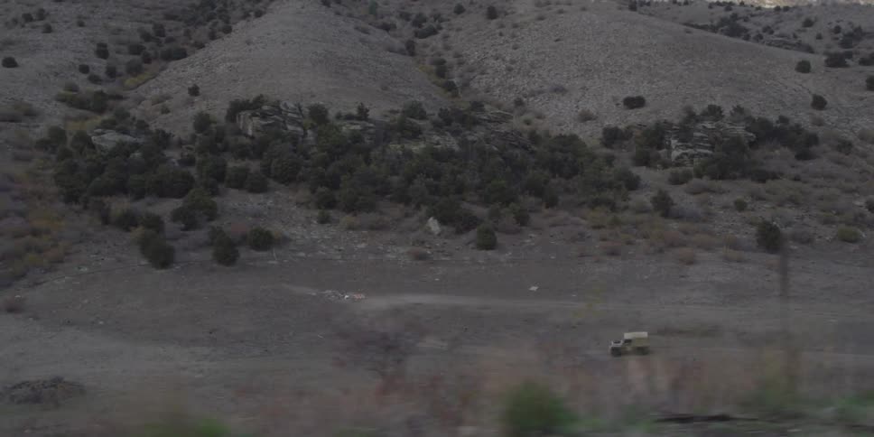 A jeep is travelling on a lonely road in the middle of a deserted place