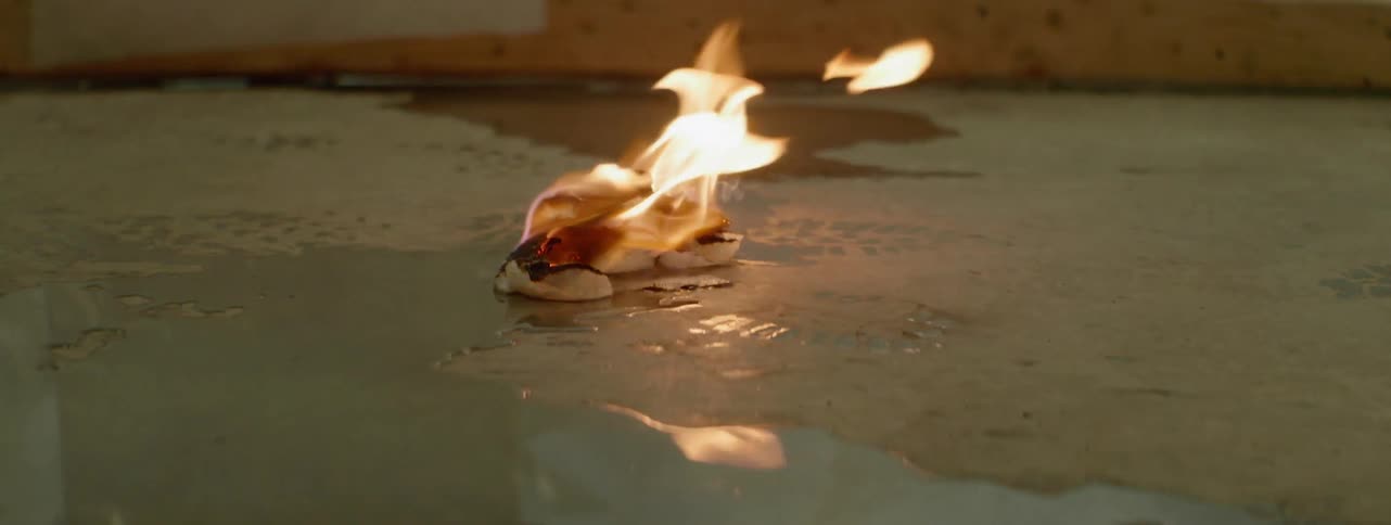 A rag is burning near a puddle in the street