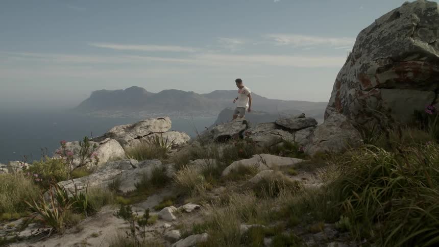 Man jumps from rock to rock overlooking the ocean