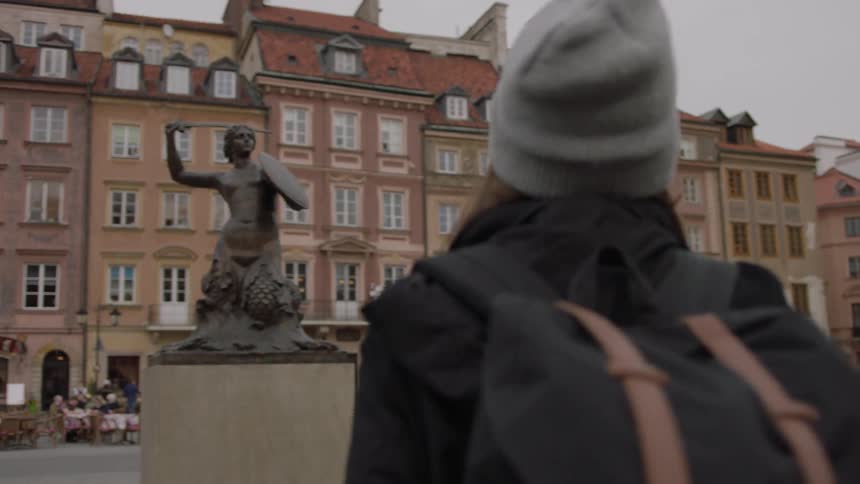 Woman walks in a city square