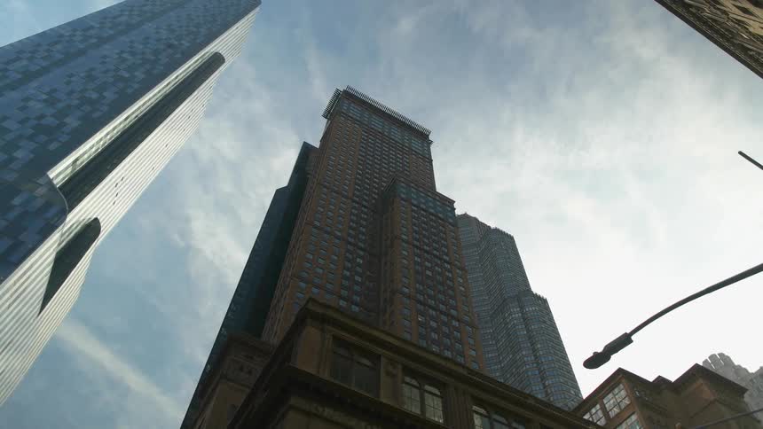 Tall buildings sit under a blue sky