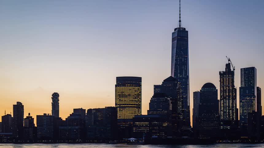A city skyline changes from dusk to dawn