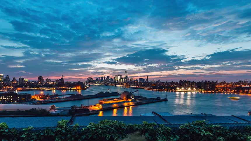 Boats floating down a river turning into night