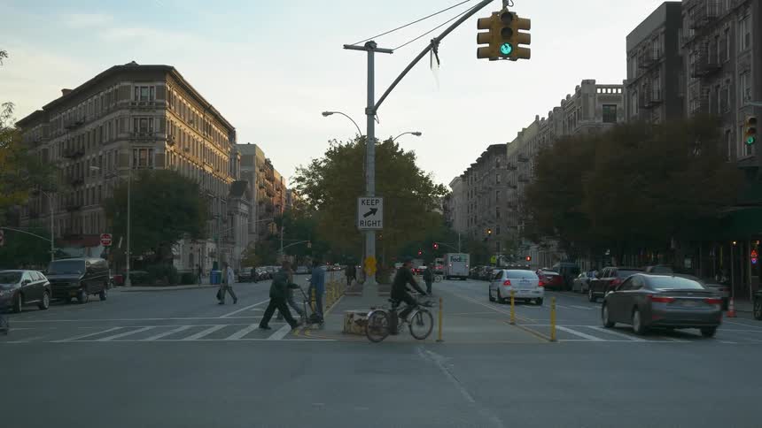 People and cars traveling down a busy city street
