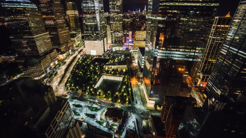 The city is brightly lit full of cars traveling
