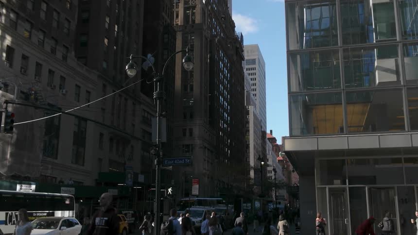 The city is full of large buildings with many people traveling