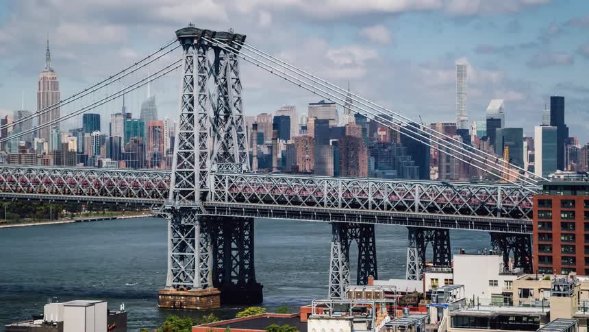 Traffic travels over a bridge under a cloudy blue sky