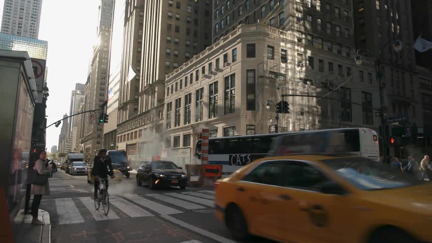 Vehicles travel down a busy city street