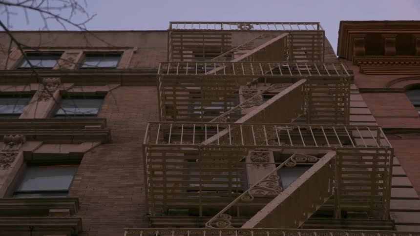 A fire escape hangs outside of an apartment building