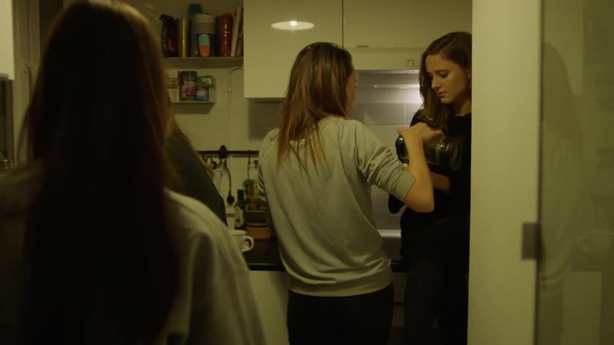 A group of women gather in the kitchen