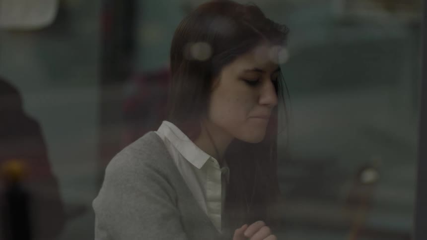 Woman sitting next to a window looking at her phone