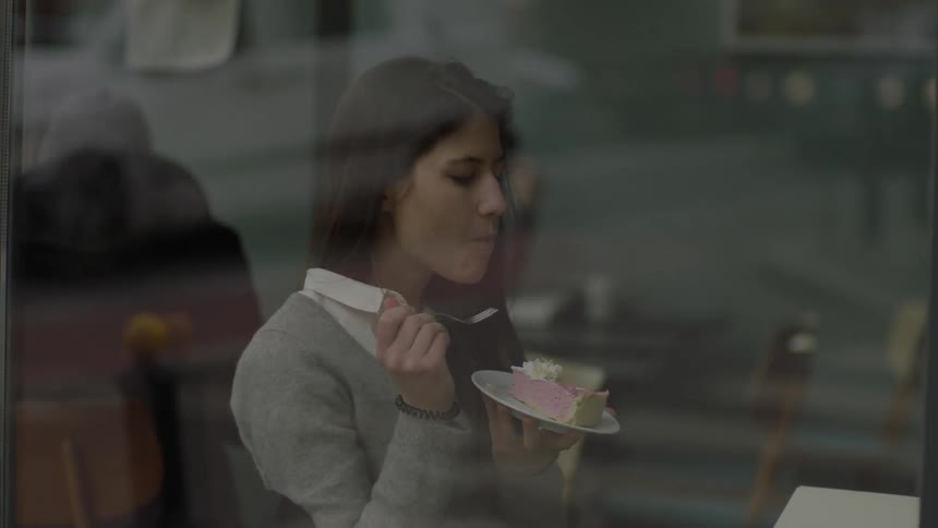 A woman takes a bite of pink pie