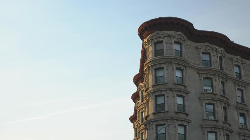 An old building with many windows stands out against a blue sky