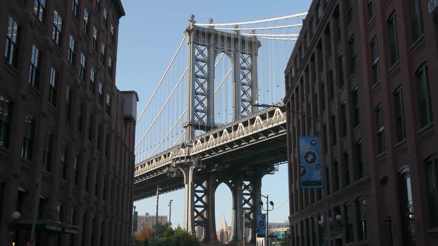 A city bridge stands at the end of the street