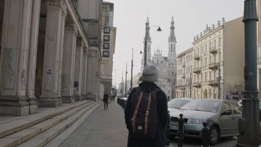 A woman walks down a city sidewalk