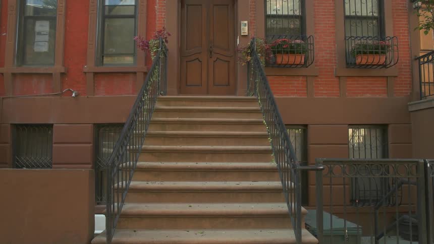 A brownstone building has a wooden door