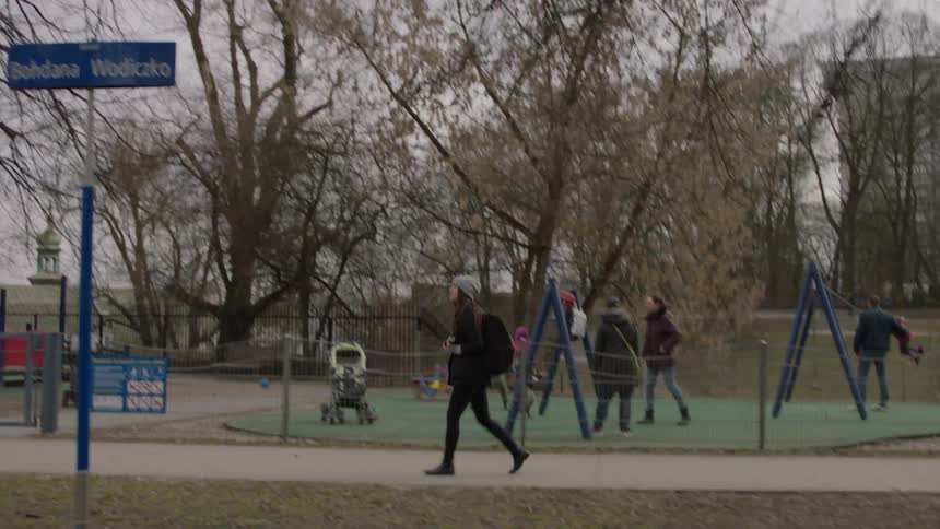 A woman walks past a busy playground
