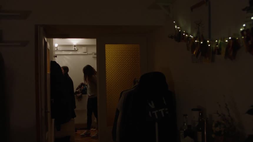 People putting coats on in a hallway
