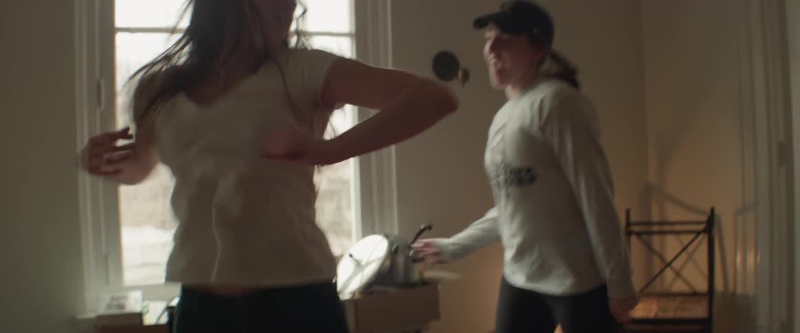 Two women dance in the living room