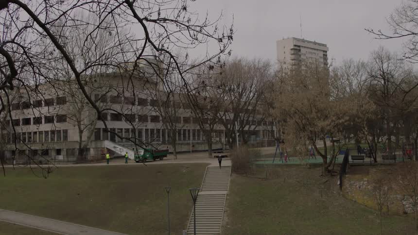 People walk down the sidewalk near buildings