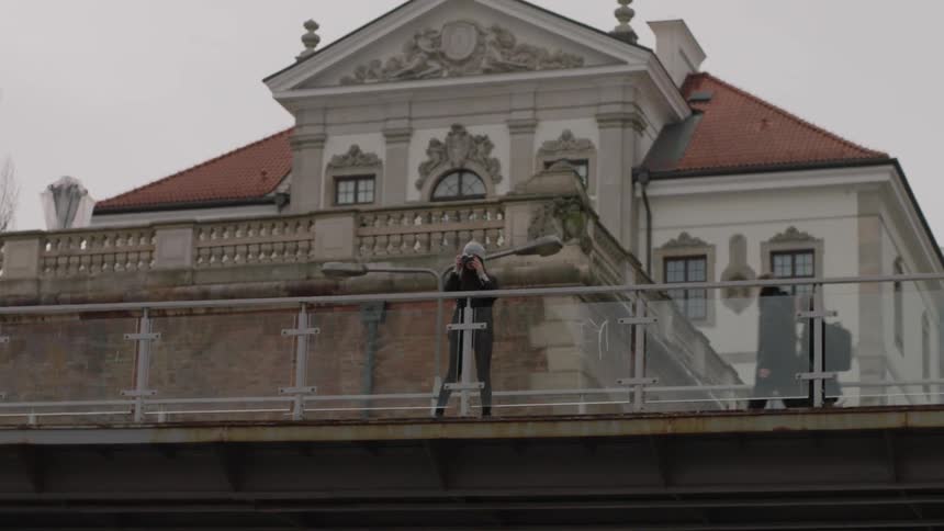 Woman walks on a bridge and stops to take a picture