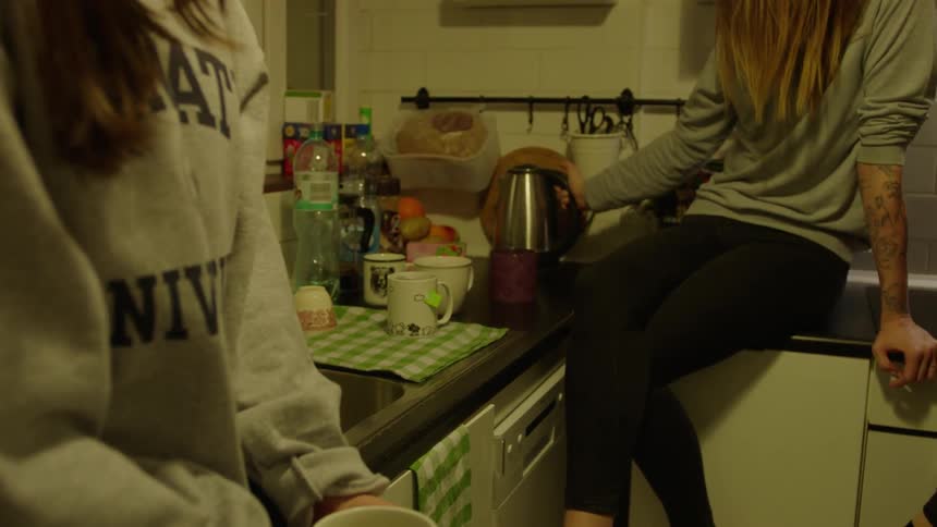 A group of women drink in the kitchen