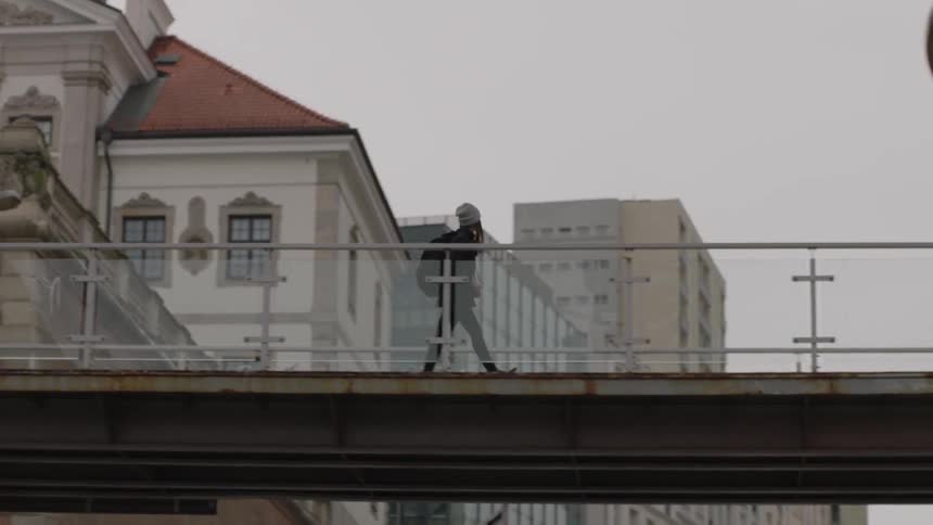 A girl walks across a catwalk in the city
