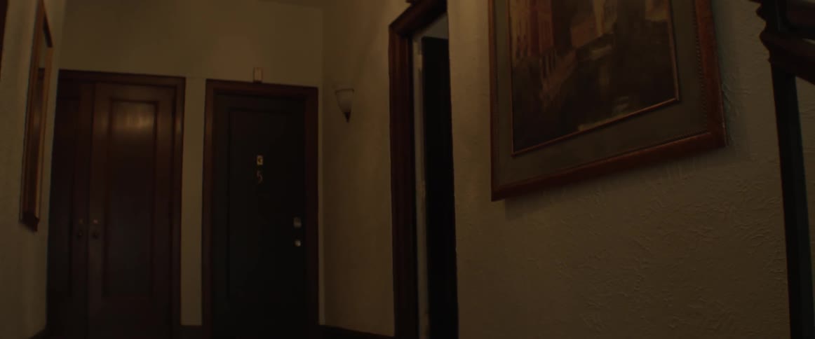 A woman carries a mattress into an apartment