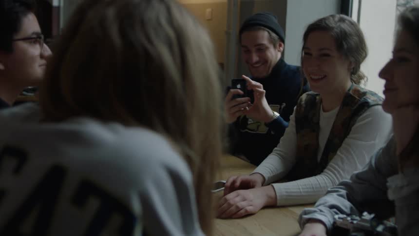 Man takes a picture with a camera as he sits with a group of people