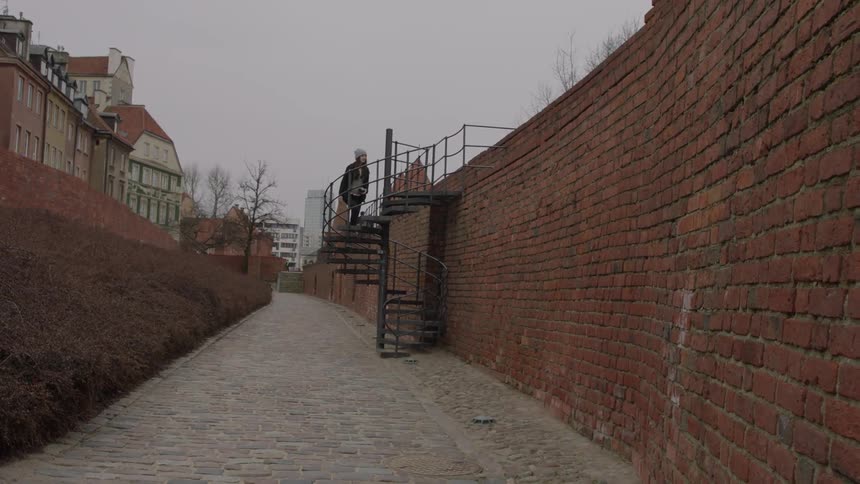 A woman climbs the spiral stairs to the top of the wall