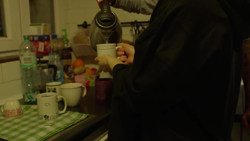 A person is served tea from a kettle