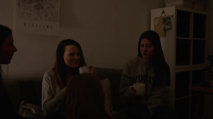 A group of women talk and drink in the living room