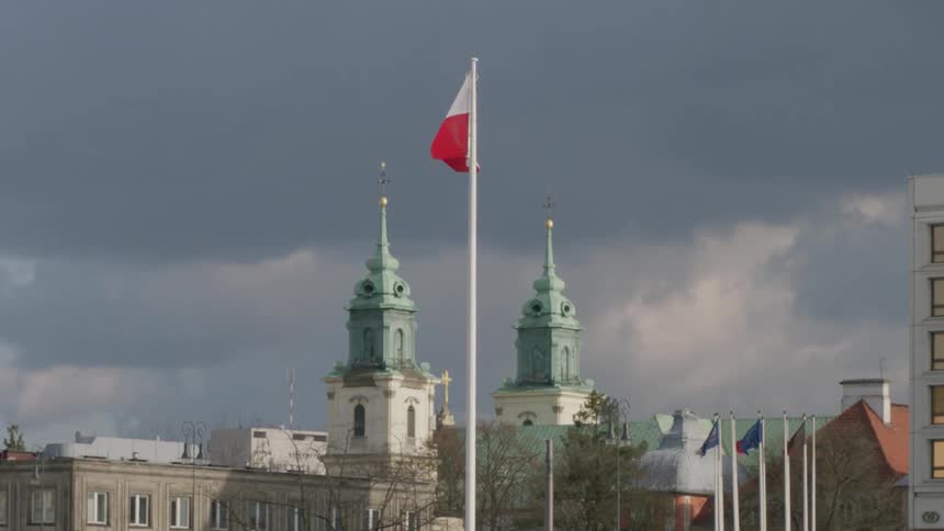 A flag flies in the middle of two towers behind it