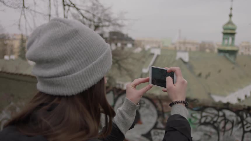 Woman standing on a bridge taking pictures