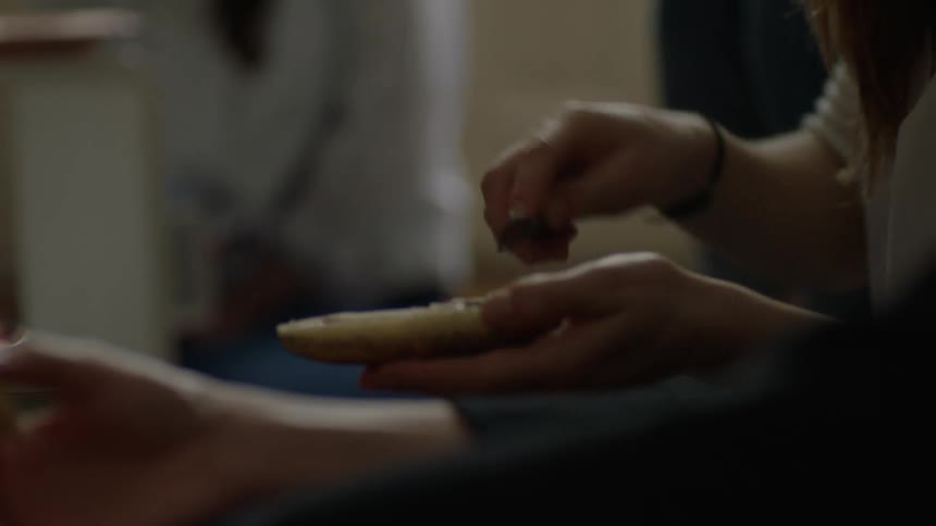 Woman butters a piece of bread talking to a man