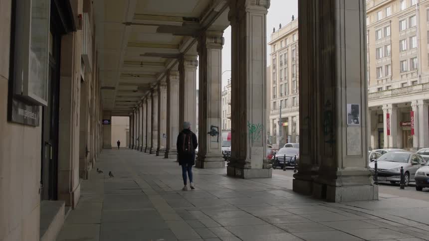 A woman stops to take a photo of a building