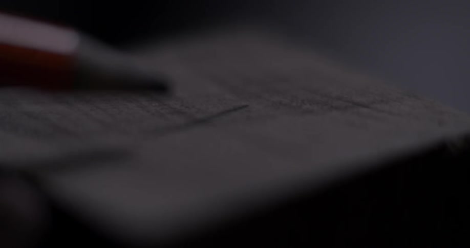 Close up of a pencil marking lines on a log