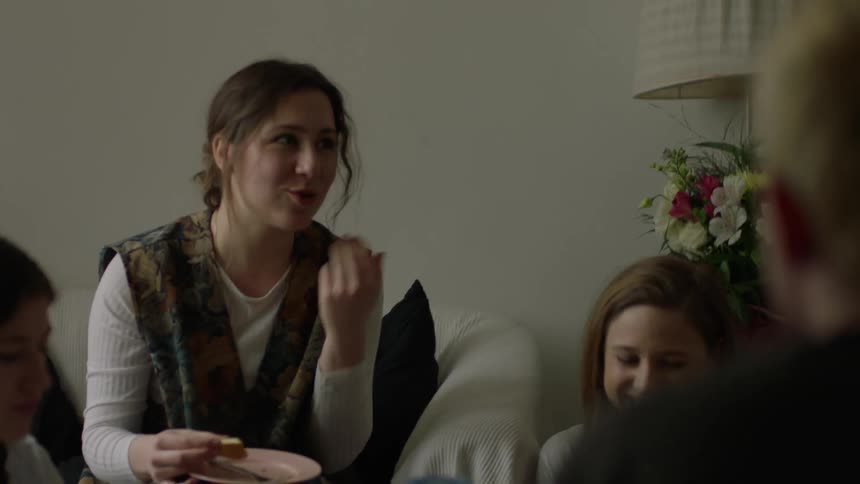 A group of women eat together in the living room