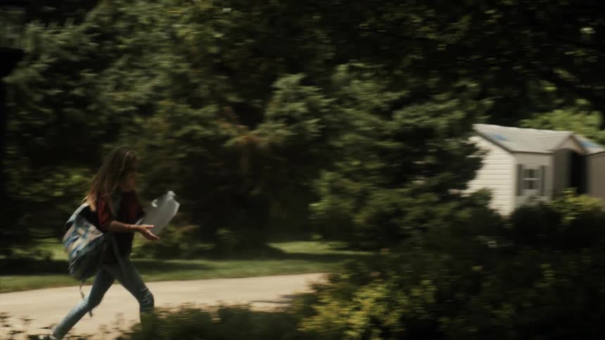 A girl runs from her car with her backpack