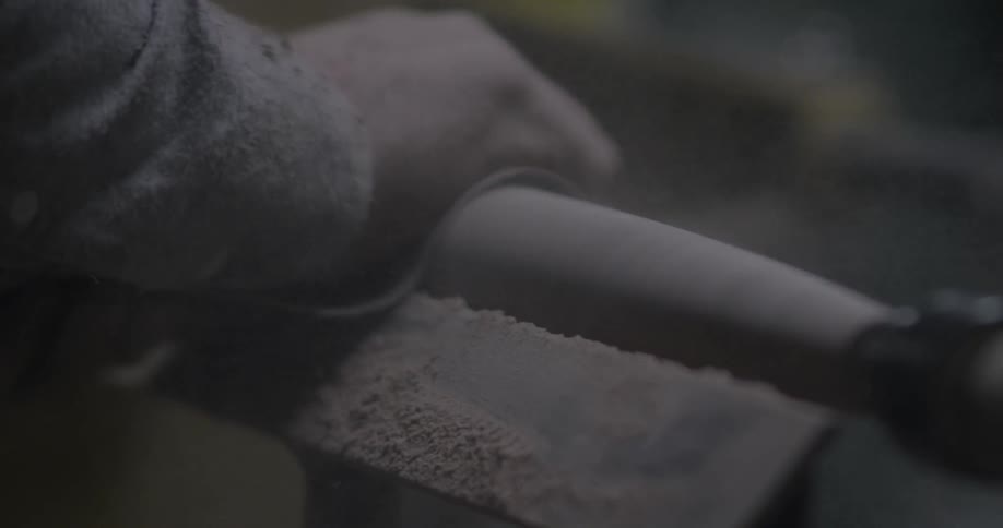 An artisan is sanding a piece of wood
