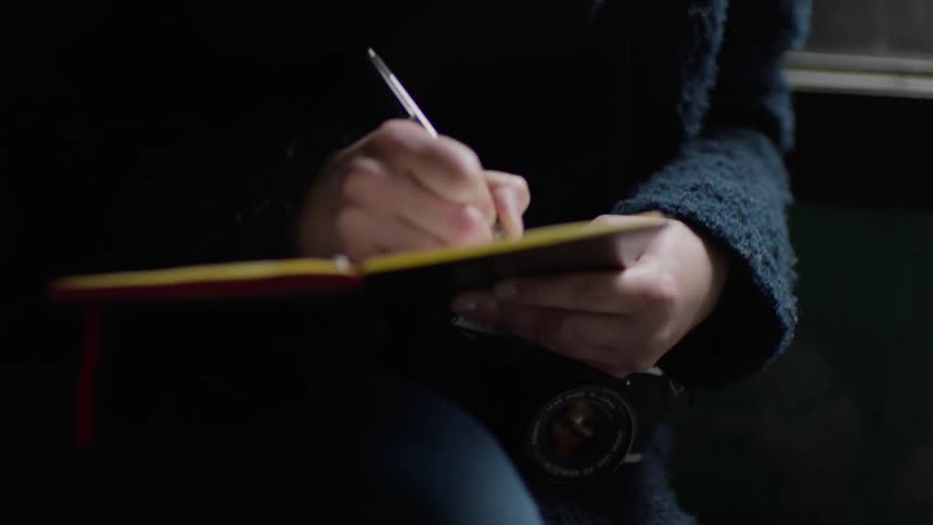 A woman writes in a journal