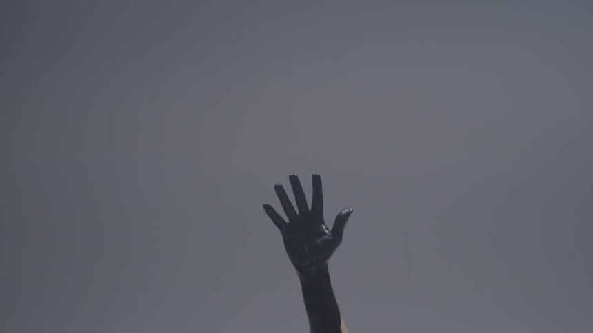 A person's hand is rising from the bottom of the screen