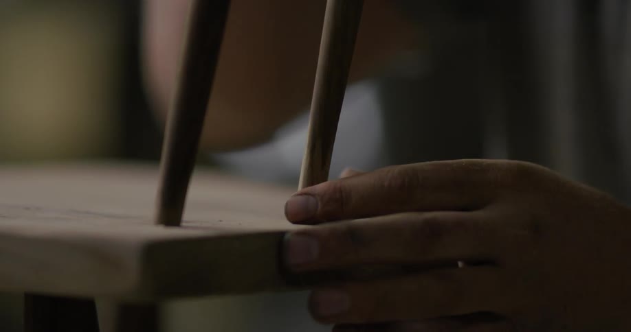 Person puts piece of wood together to form a chair