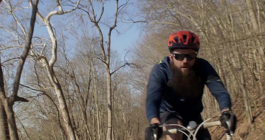 A man is riding his bike fast down the trail