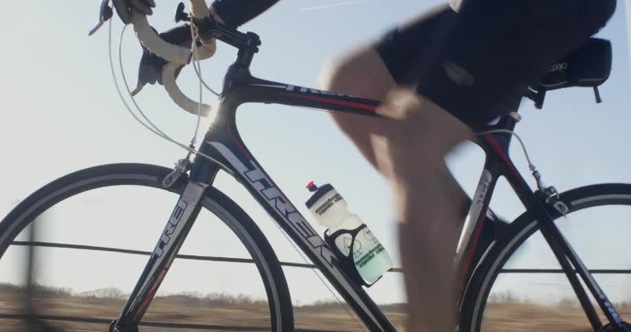 A man is riding his bicycle on a sunny day