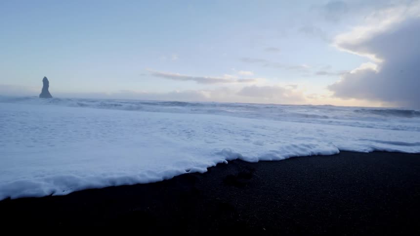 The waves slowly come over the beach