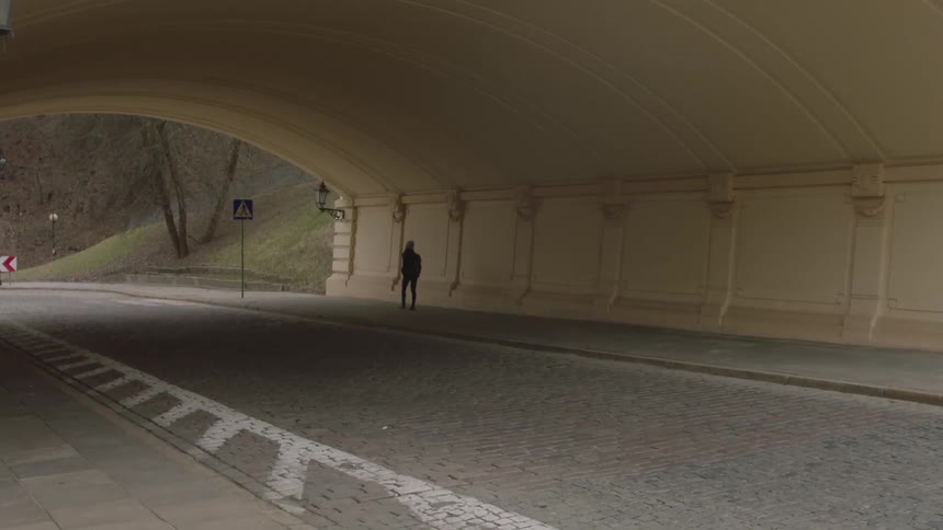 Person walks through a tunnel in a city