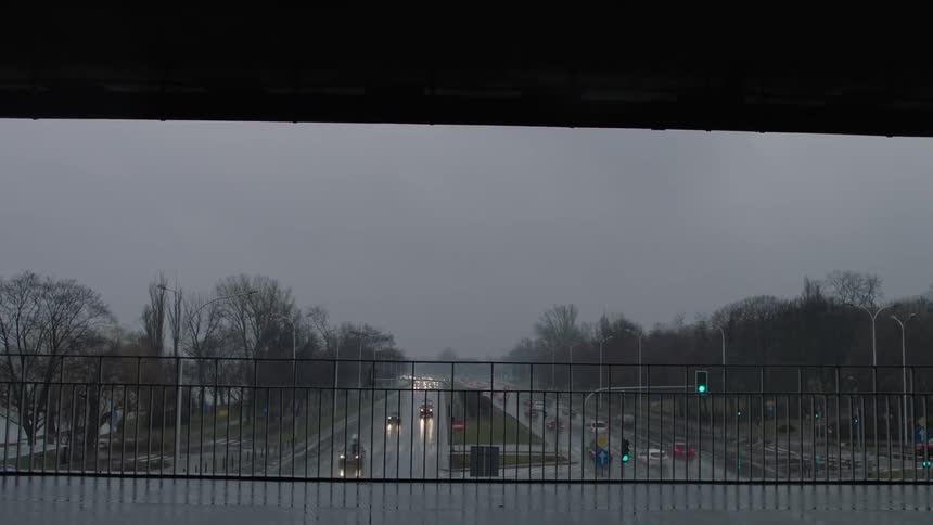 The overpass railing shows the cars driving below