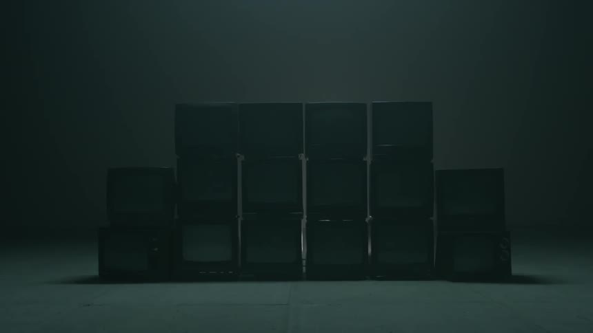 A pile of tvs sits in a warehouse